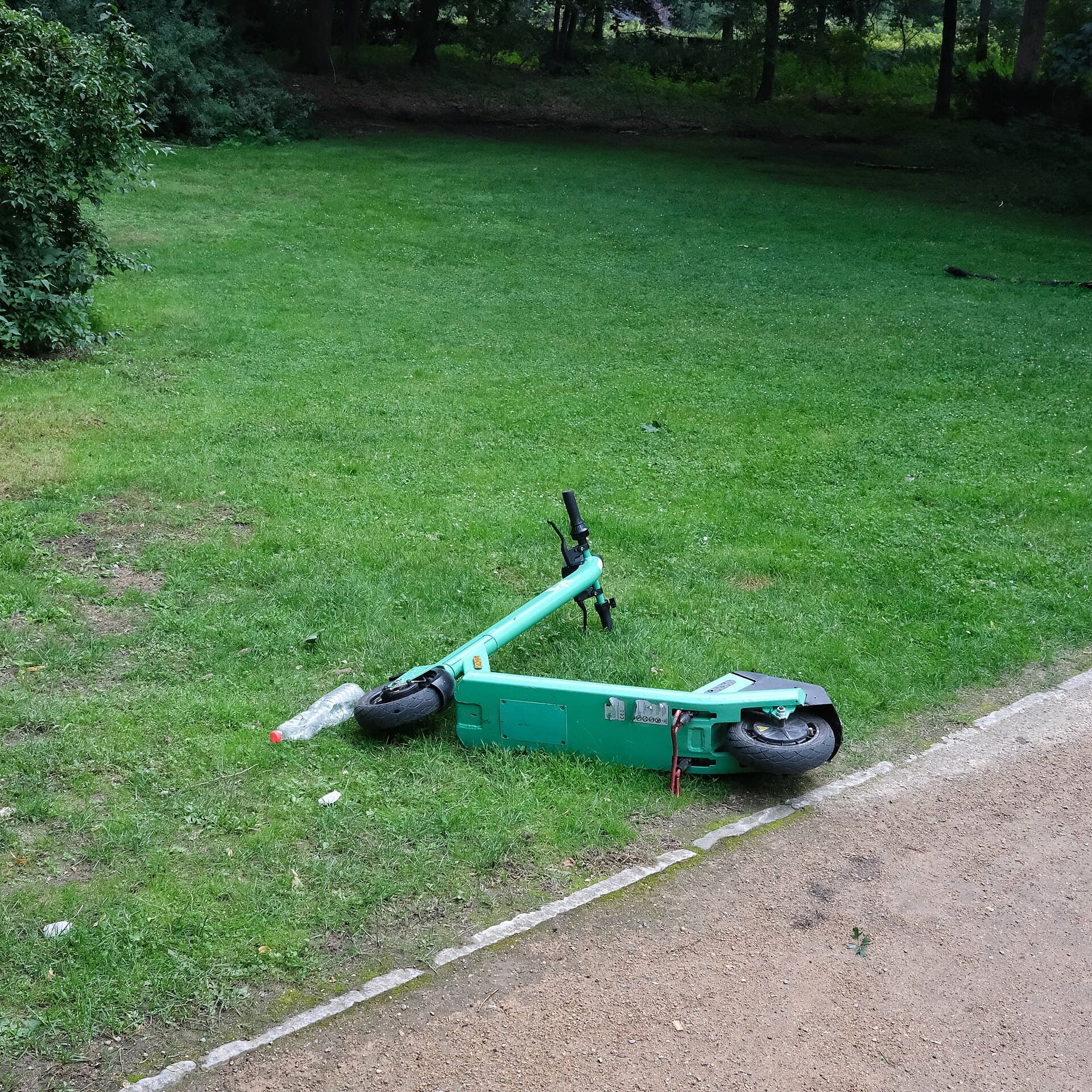 Ein E-Scooter auf einem Weg in einer Grünanlage